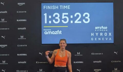 Stéphanie, adhérente du club SMLV, devant l'écran affichant son temps de 1 h 35 min 23 s à la fin du HYROX de Genève